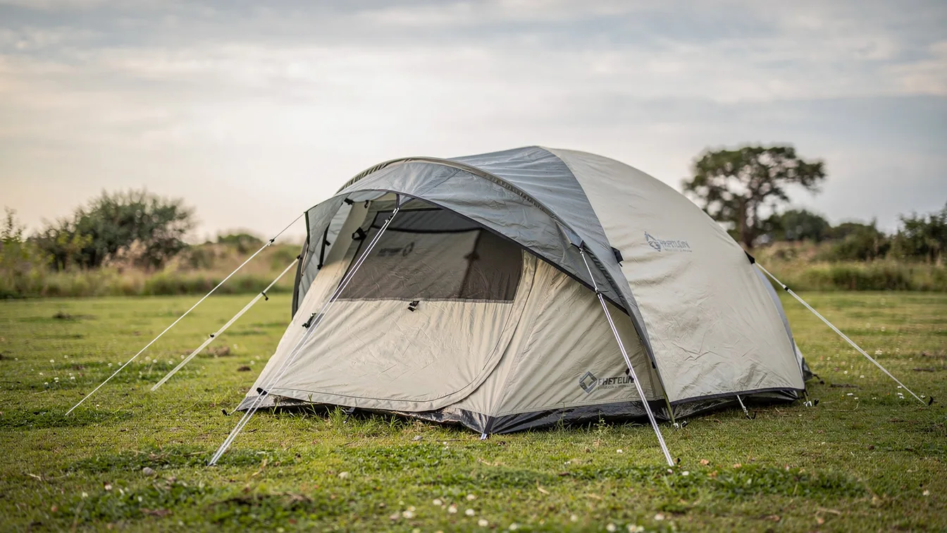 A lightweight circular family camping tent pitched on level grass with guy lines
